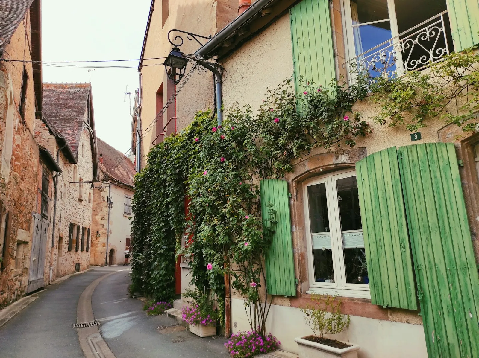 Rue de maisons aux volets verts à Hérisson, dans l'Allier