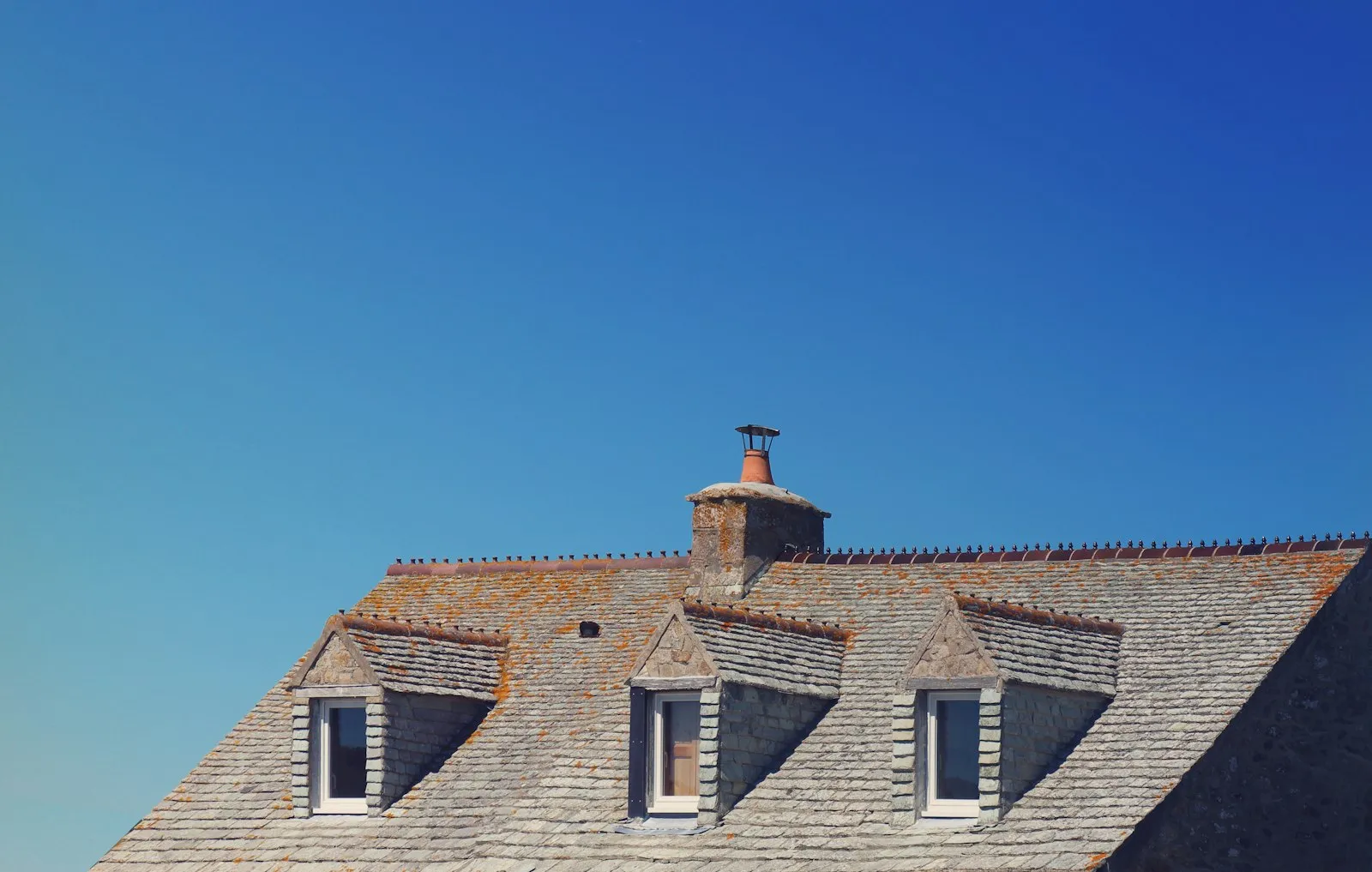 Toit en ardoise à trois lucarnes d'une maison de Jobourg, dans la Manche