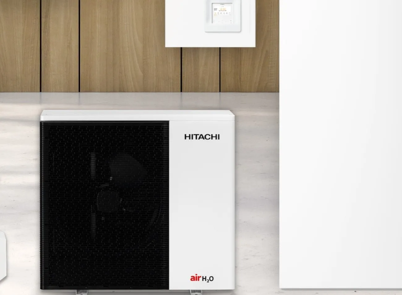 Deux unités extérieures de pompe à chaleur air/eau et leur module intérieur devant un bardage bois, graminées au premier plan