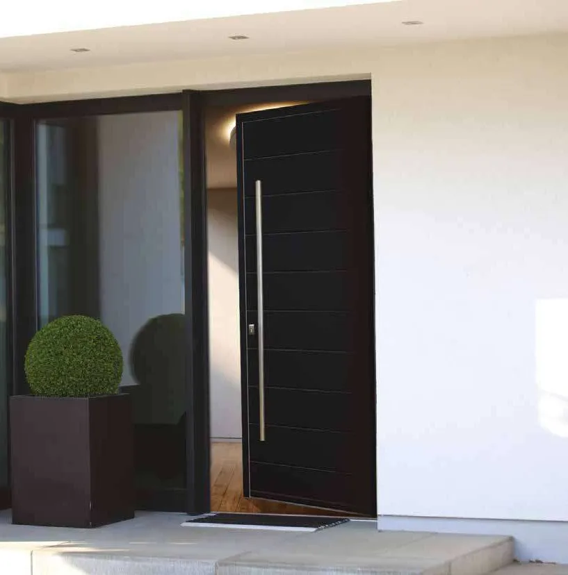 Porte d'entrée pivotante en aluminium noir à longue poignée, maison contemporaine blanche