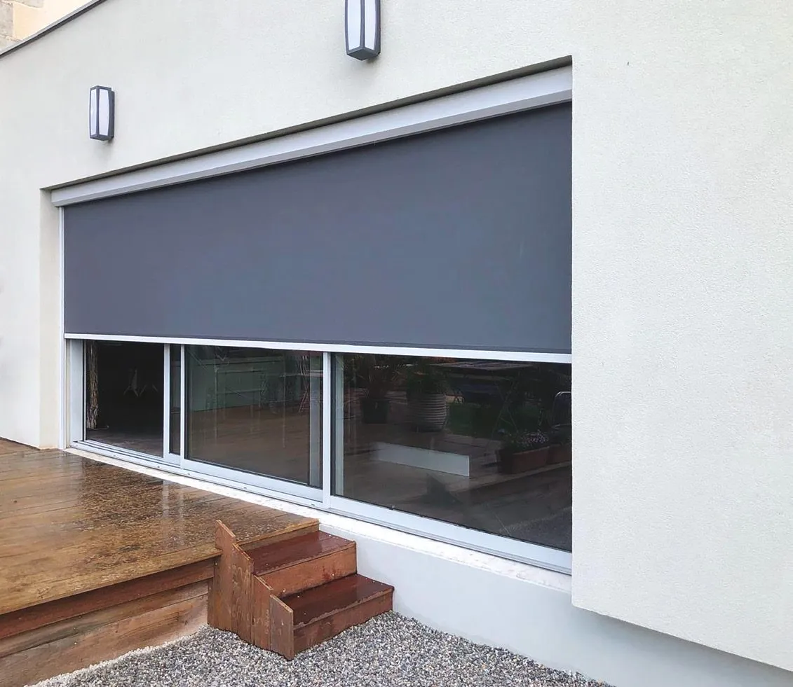 Store screen déroulé devant une baie vitrée