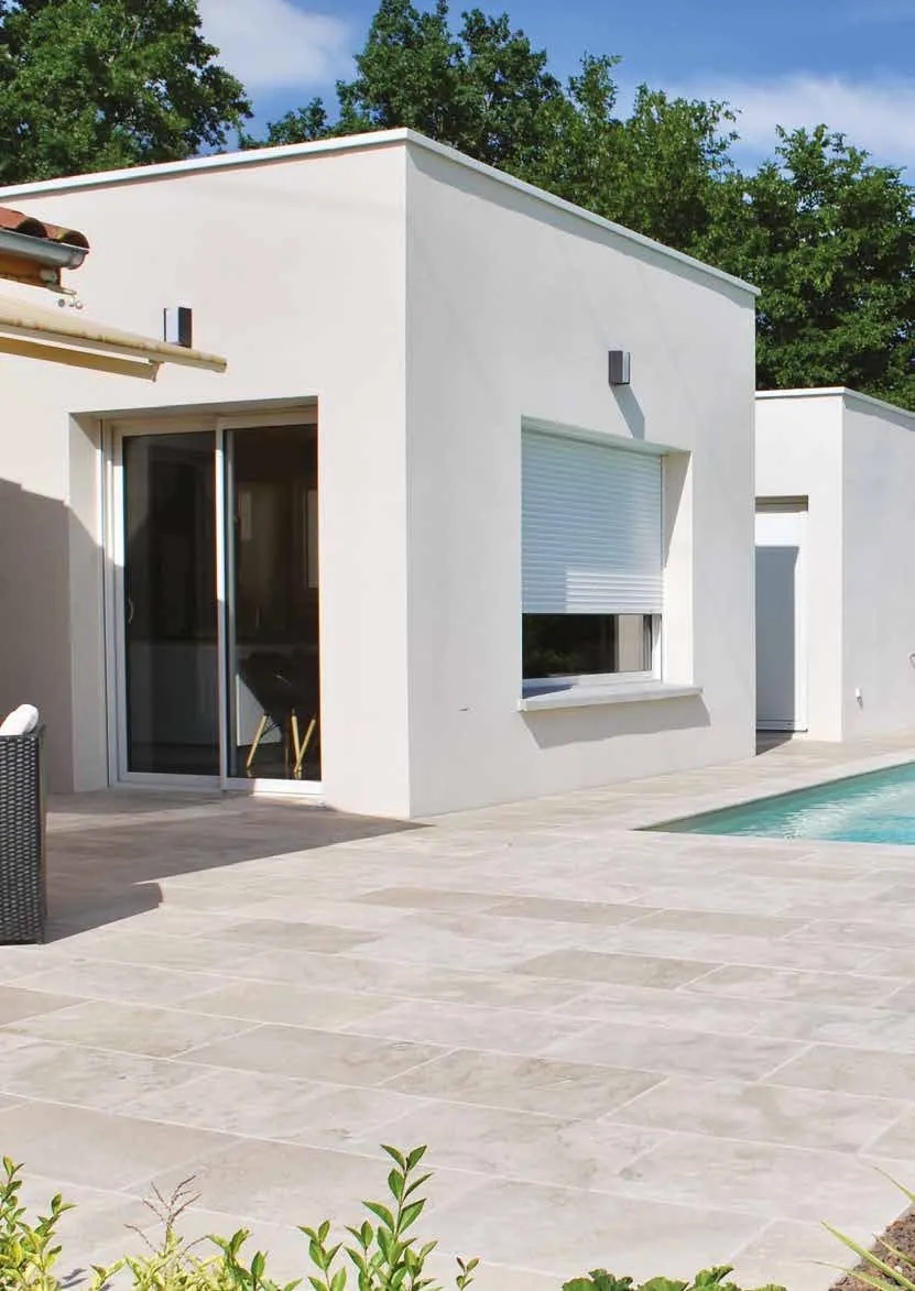 Maison contemporaine blanche, baie coulissante et volet roulant blanc à demi baissé, piscine